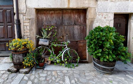 Old and decorative bicycle leaning against old wooden door at  traditional village in Spainの写真素材
