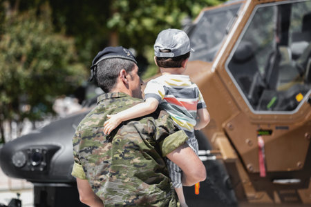 Seville, Spain - May 30, 2019: Soldier with little boy watching Attack Helicopter HA.28 Tiger during display of Spanish Armed Forces Day in Seville, Spainのeditorial素材