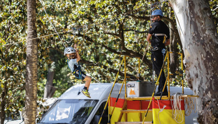 Seville, Spain - May 30, 2019: Emergency Unit instructor assisting kid in zip line during display of Spanish Armed Forces Day in Seville, Spain.のeditorial素材
