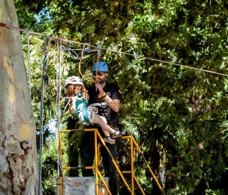 Seville, Spain - May 30, 2019: Emergency Unit instructor assisting kid in zip line during display of Spanish Armed Forces Day in Seville, Spain.のeditorial素材