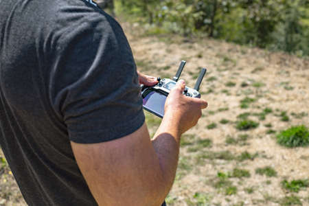 Man operating a drone with remote control. Close up. Selective focus.の写真素材