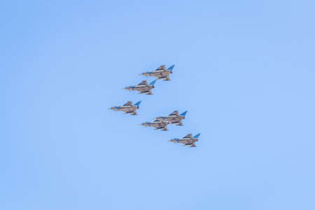 Modern armed military transport planes flys in formation through the sky.