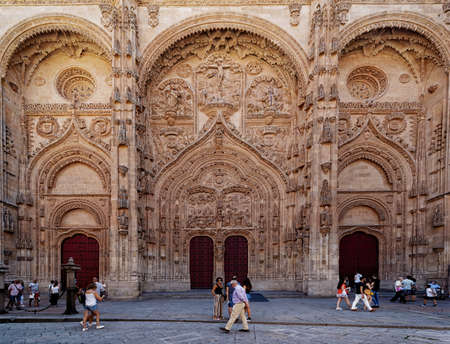 Seville, Spain - August 03, 2019: Main facade of the New Cathedral of Salamanca. Profuse details among which the reliefs of the Nativity and Epiphany scenes stand out on the doors, all sheltered under a large ogee arch that is culminated by a superb Calvaのeditorial素材