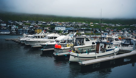 Klaksvik, Faroe Islands - July 19, 2019: Fishing and sailing boats in the harbor of Klaksvik. It is...
