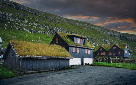 Nice sunset on Traditional turf houses in Village of Kirkjubour. Typical black houses in Faroe Islands, Denmark, Northern Europe.のeditorial素材