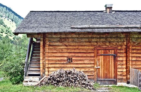 Log cabin with small window, door and small wood stackの写真素材