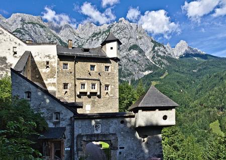 Outside view of Castle Hohenwerfen, Austria with wall, towers, gatehouse and the rocky peaks of the Tennen range in the Austrian Alps in the backgroundの写真素材