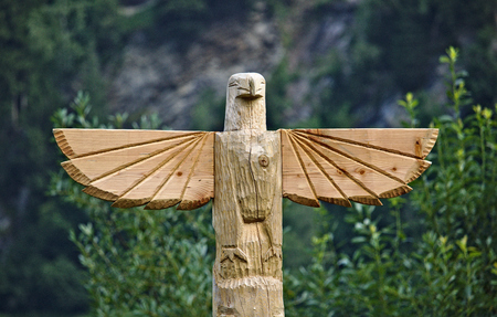 Wooden carved eagle on top of huge totem poleの写真素材