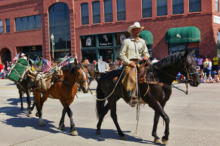 Cody, Wyoming, USA - July 4th, 2009 - Member of the US Forest Service mounted on his horse leading several packhorses in the Independence Day Paradeのeditorial素材