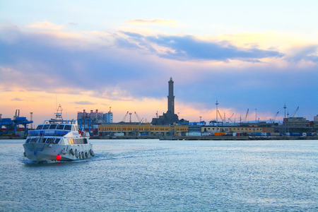A boat sailing in golden hour to Genoa ancient harbor, lighthouseの写真素材