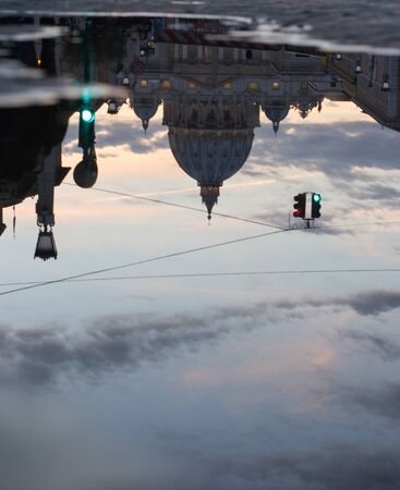 Puddle reflecting Sant Peter cathedral dome in the long street to the holy place one of the best point of interest in Vatican area in Rome.の写真素材