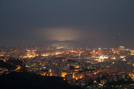 Moon light on the sea coast , the buildings in this pictures do a lot of artificial lights, night view of the sea coast from mountainの写真素材