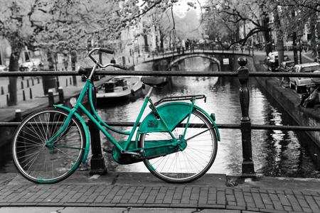A picture of a lonely azure bike on the bridge over the channel in Amsterdam. The background is black and white.の写真素材