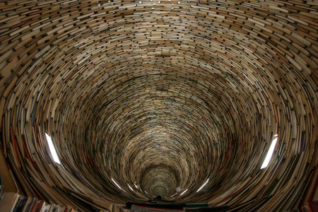 A picture of a tunnel made of books. Looking quite hypnotic. It is made of books and mirrors.の写真素材