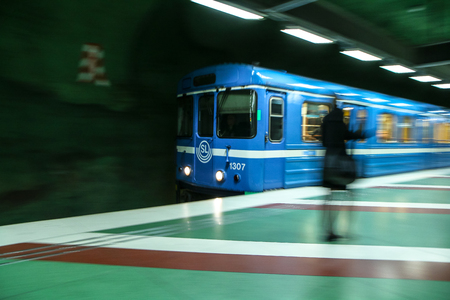 The traditional blue metro train in Stockholm is arriving into the station.