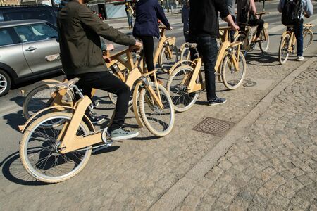 People are standing by their wooden, bamboo, bikes.の写真素材