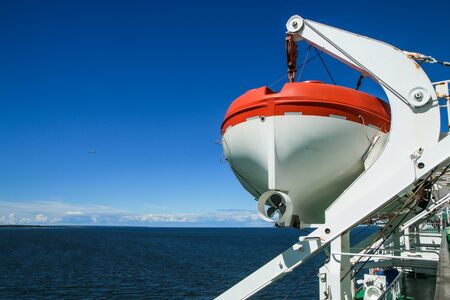 A detail part of a big sea ferry, the rescue boat hanging on chains on the side of the ship.の写真素材
