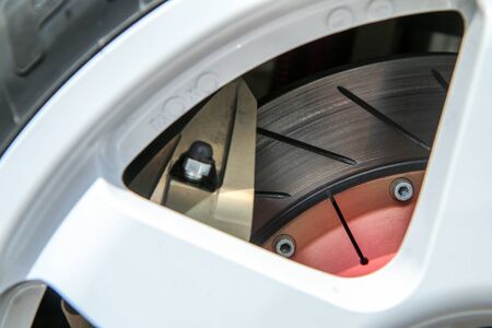 The detail of a Wheel of a rallye car with part of the rim, brake disc and calipers visible.