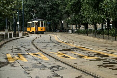 A picture of the typical yellow tram in Milan, Italy, passing throught the city center.の写真素材