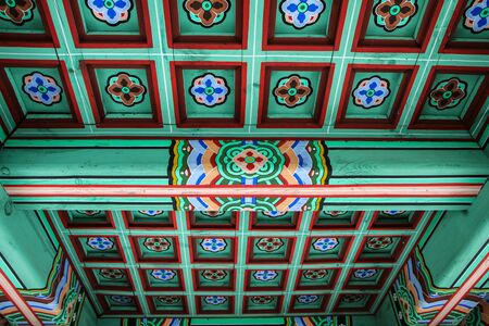 A detail Picture of a traditional wooden roof of a Korean palace. You can see the ornaments and decorations.の写真素材
