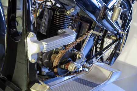 The detail of the old motorcycle with part of the frame, engine, fuel tank and leather belt for...