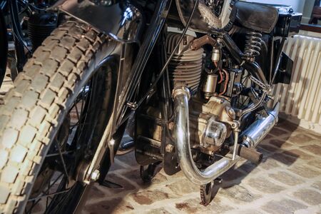 The detail of the old motorcycle with part of the frame, engine, fuel tank and fuel lead.