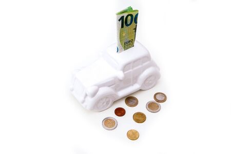 The ceramic car shaped money box with a banknote inside. It can be symbol for costs for carÂ´s repairs, investment, savings or insurance.の写真素材