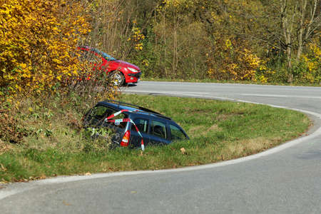 The car in the ditch by the road after the traffic accident. Abandoned and waiting for tow.