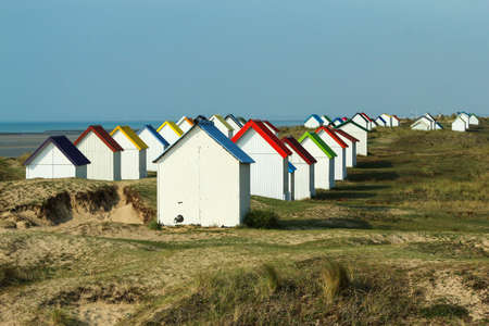 The tiny white beach cottages with colorful roofs at a beach by Gouville-sur-Mer in France in Normandy. The attraction for the tourists.の写真素材