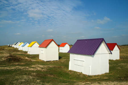 The tiny white beach cottages with colorful roofs at a beach by Gouville-sur-Mer in France in Normandy. The attraction for the tourists.の写真素材