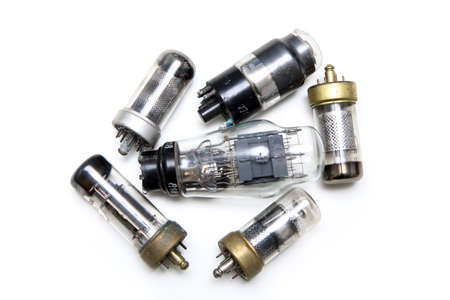 The small group of vacuum or electron tubes isolated on a white background. The obsolete electronic...