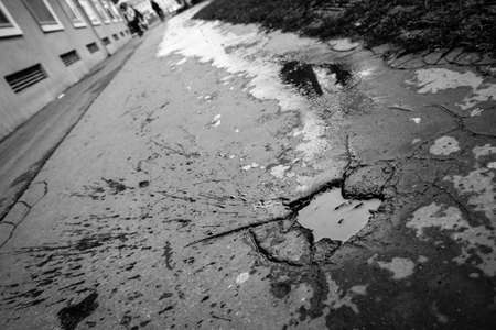 A picture of the pothole on the pavement. The water is inside, the spatter from the people or bikes is visible.の写真素材