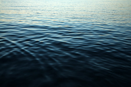 The detail of the calm surface of the sea with the small waves during the evening while the sun...
