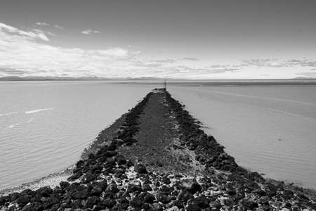 rocky pier at the end of Iona Beach Jetty in Black & Whiteの写真素材