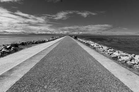 rocky pier at the end of Iona Beach Jetty in Black & Whiteの写真素材