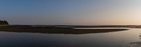 Panorama of the low tide on the beach in the evening.の写真素材
