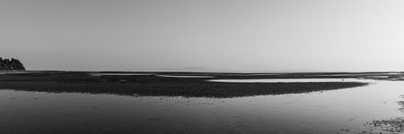 Black and white panoramic view of the beach at low tideの写真素材