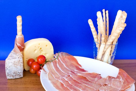Food & Drinks -  italian appetizers: ham, cheese, bread-sticks and cherry tomatoes.の写真素材