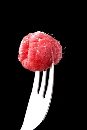 Fruits - Fork with raspberry isolated on black background.の写真素材