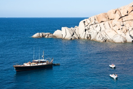 Capo Testa, Sardinia, Italy, August 11, 2009 - People with yacht and dinghies enjoying to beautiful weather in the blue waters of the sea, on sardinian coast of Capo Testa. のeditorial素材