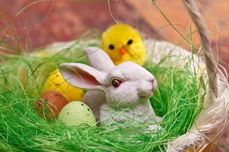 Easter basket with candy eggs, bunny and chicken.