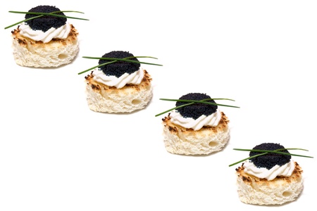 Food Backgrounds  - Red and black caviar canapés decorated with chives, on white background の写真素材