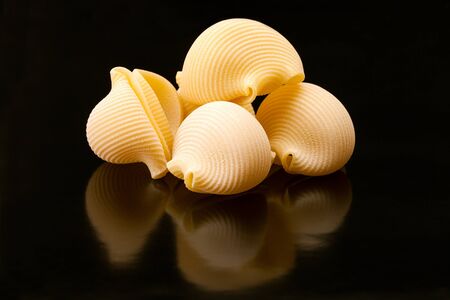 Closeup of lumaconi pasta on black background の写真素材