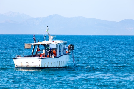 Fishing boat at work in the sea - Punta Ala, Tuscany, Italy の写真素材