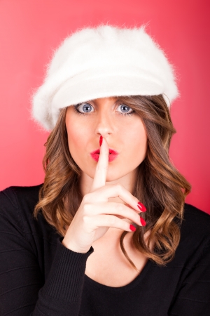 Woman with finger near lips asking the silence.の写真素材