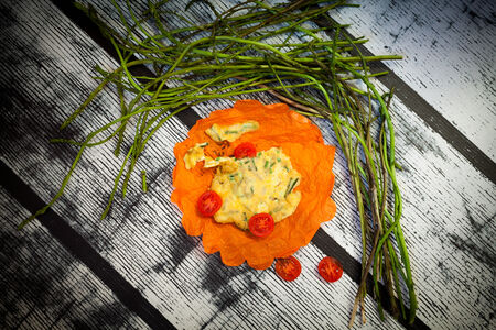 Wild asparagus omelette decorated with slices of cherry tomatoes.の写真素材