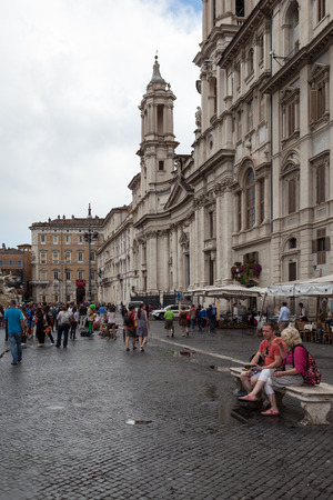 ROME, ITALY - JUNE 18, 2014: Couple of tourists taking a break on a bench in Piazza Navona. Piazza Navona is one of the most famous touristic attractions of Rome.のeditorial素材