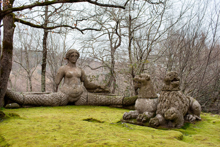 Mythical figures in the Sacred Wood of Bomarzo, Italy: Echidna at left with woman body and serpent tail and two lions at right.の写真素材