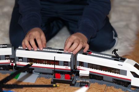 ROME, ITALY - DECEMBER 28, 2015: Child playing with the high-speed passenger train from LEGO CITY . Lego is a popular line of construction toys manufactured by the Lego Group.のeditorial素材