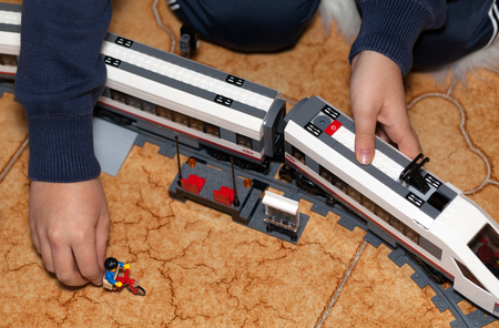 ROME, ITALY - DECEMBER 28, 2015: Child playing with the high-speed passenger train from LEGO CITY . Lego is a popular line of construction toys manufactured by the Lego Group.のeditorial素材